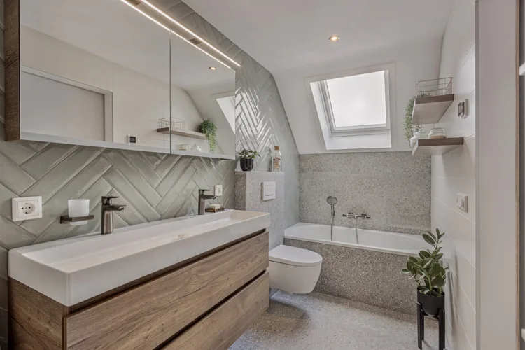 Een lichte badkamer met houten wastafelmeubel en dakramen.