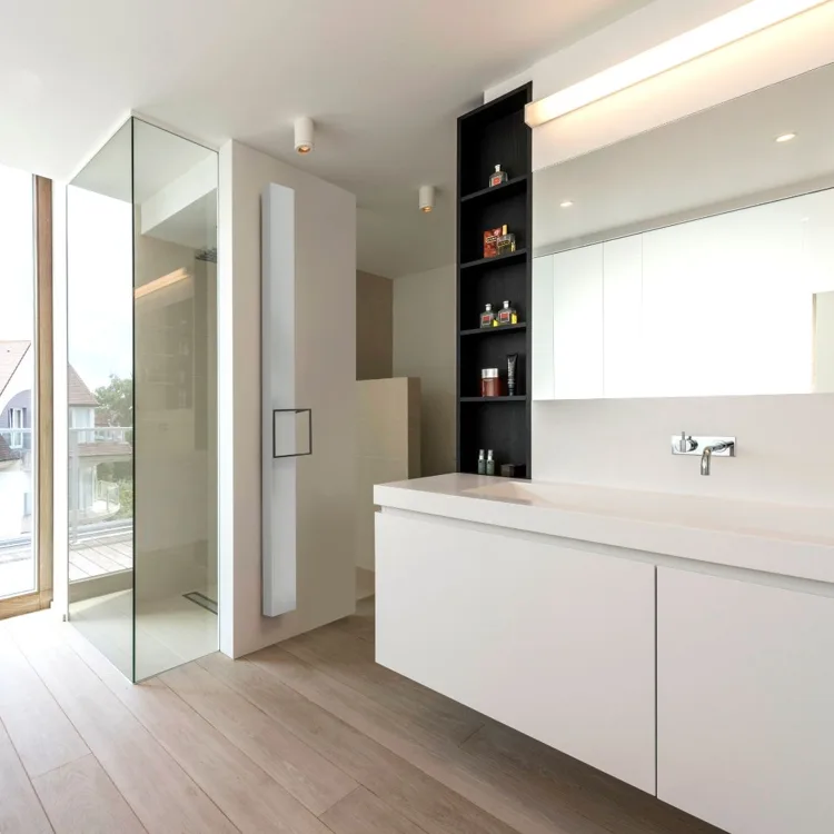 Heldere witte badkamer met breed meubel en inloopdouche.